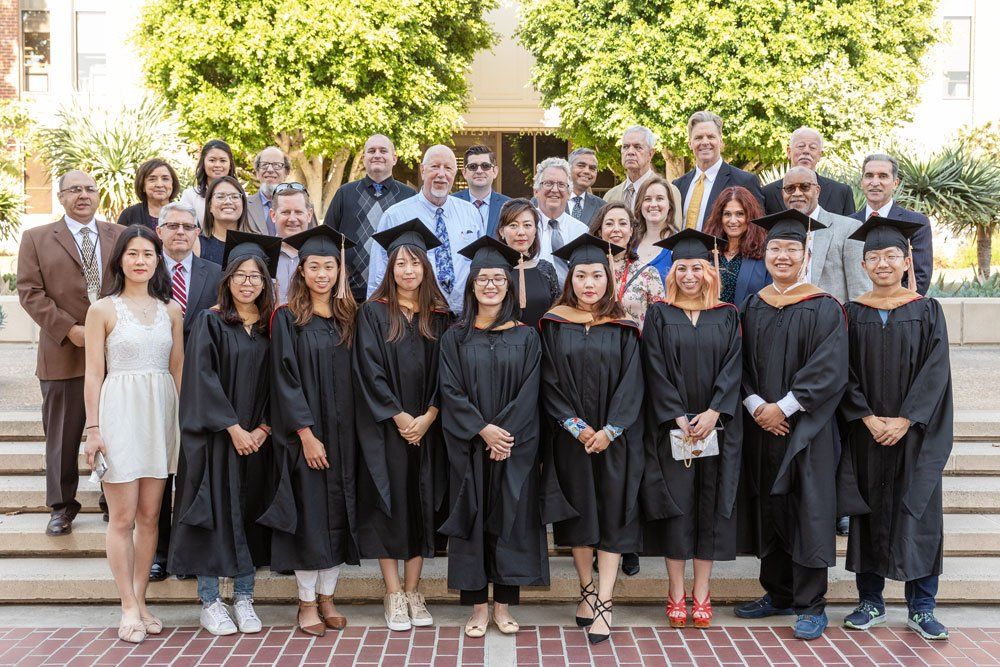 A large group of graduates are posing for a picture.