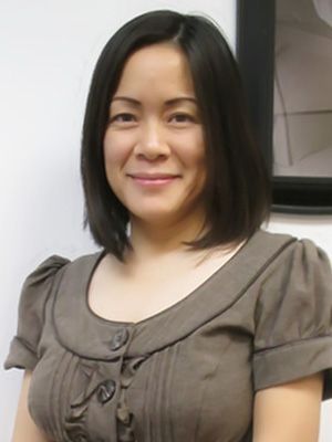 A woman in a brown dress is smiling for the camera