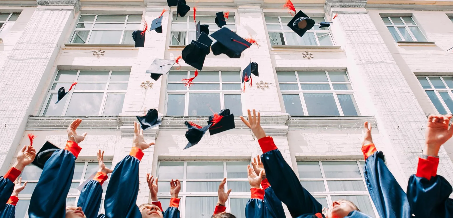 A group of graduates are throwing their caps in the air.