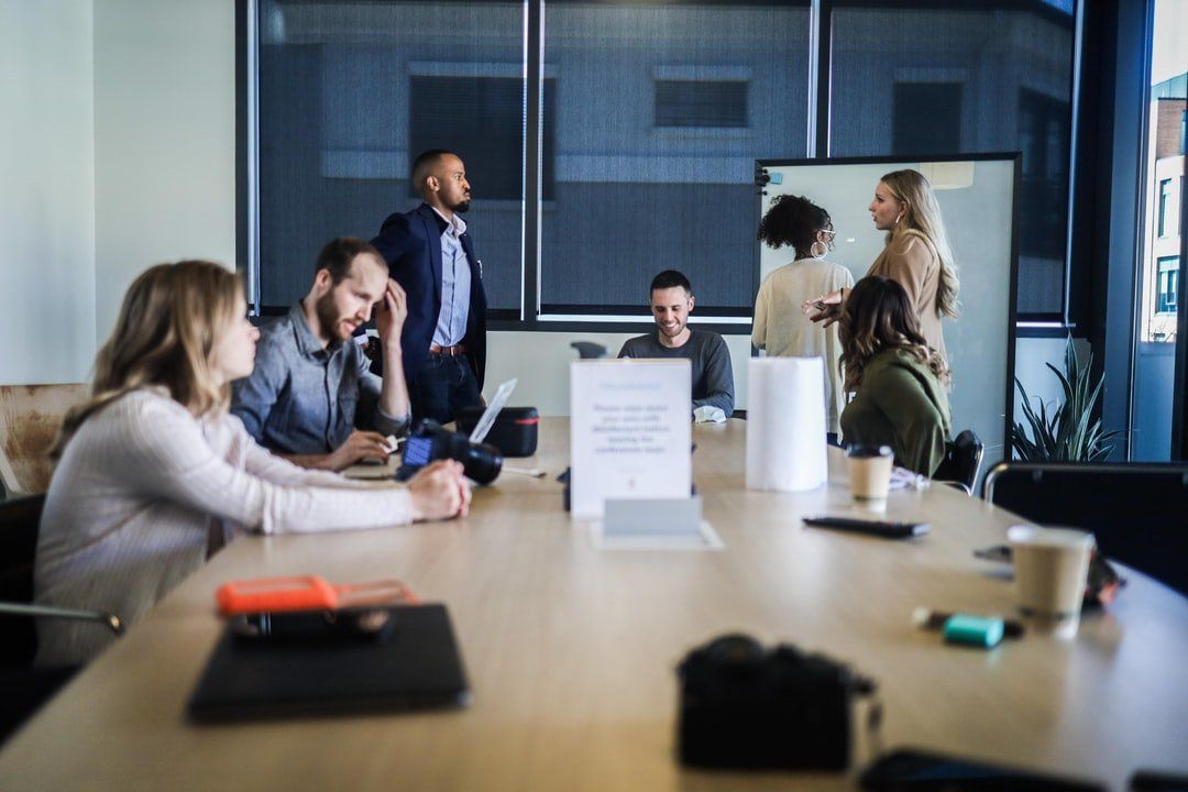A group of people are sitting around a table in a conference room.